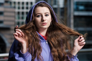 Wall Mural - Portrait of a young woman in a purple hooded sweat, financial environment.