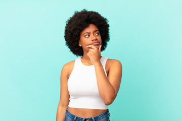 Wall Mural - afro black woman thinking, feeling doubtful and confused, with different options, wondering which decision to make