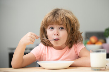 Caucasian toddler child boy eating healthy soup in the kitchen. Healthy nutrition for kids. Child nutrition.