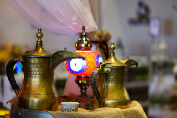 Turkish pitchers. an ancient islamic kettle and Table lamp. Close Up of pitcher in arabic style. Two oriental copper jugs. Oriental islamic middle eastern decor, selective focus