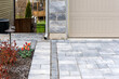 Luxury hardscape driveway shows pavers with pattern and  and gravel and slab steps along the sideyard.