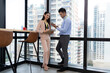 © bung - Business team discussing together in the modern high level building. Man holding tablet. Woman holding clipboard and standing beside windows. Teamwork, brainstorm and idea concept