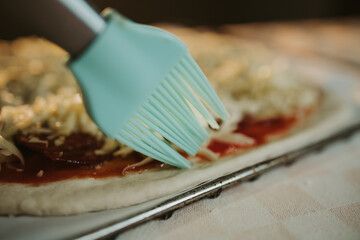 Sticker - Closeup shot of spreading oil o homemade pizza crust