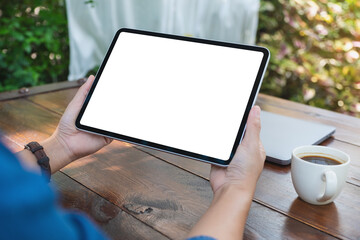 Mockup image of a woman holding digital tablet with blank white desktop screen in the outdoors