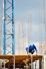 Wall Mural - Real construction worker working on a high building and leveling floor for cementing.