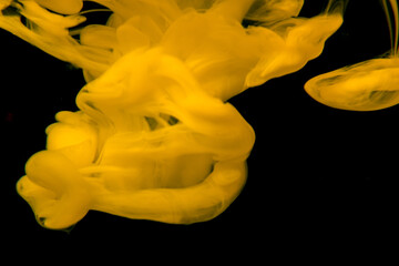 Closeup shot of yellow smoke on a black isolated background