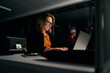 © StratfordProductions - Portrait of a happy young female business executive using laptop in modern office