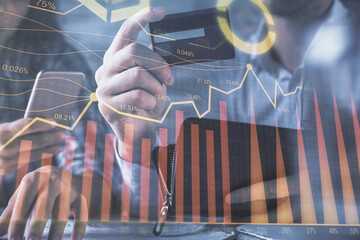 Aufkleber - Double exposure of man and woman on-line shopping holding a credit card and forex graph hologram drawing. Stock market E-commerce pay on-line concept.