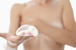 © H_Ko - Closeup of silicone breast implant in nude woman hand