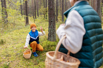 Canvas Print - picking season, leisure and people concept - happy smiling grandmother and grandson with baskets and mushrooms in forest