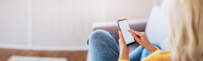 Young woman on the couch using her smartphone.