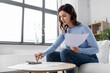 © Syda Productions - accounting, taxes and finances concept - young woman with papers and calculator at home
