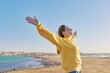 © Valerii Honcharuk - Beautiful happy mature woman with open arms closed eyes enjoying sunset on seashore