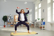 © Studio Romantic - Funny nerdy barefoot employee in glasses having fitness workout during work day. Happy fit male office worker in business suit standing on gym mat and doing sports exercise with light weight dumbbells