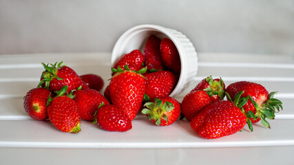 Sweet strawberries fall out of cup