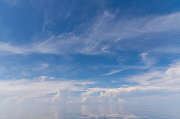 Wall Mural - Blue sky and white fluffy clouds with reflect on sea background and pattern