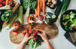 © Tijana - Table top view of woman hands making fresh salad in table full with organic vegetables. Directly above photo of housewife making lunch with fresh colorful vegetables at kitchen in home, vegan food