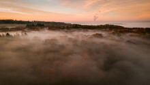 Aerial View Of A Rosy Sunset In Woodland Covered In Fog