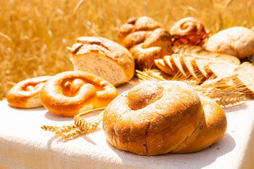 lot of different flavored bread, wheat, rye, on the table in the field outside