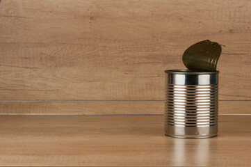 Single empty open aluminum can on wood table