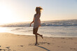 © Wavebreak Media - Caucasian woman wearing bikini and sweater having fun at the beach