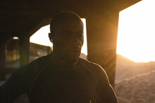 Portrait Of African American Man Exercising Outdoors Under Bridge At Sunset