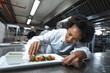 © Wavebreak Media - Mixed race professional chef finishing dish before serving with colleague in background