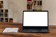 © Kateryna - Front view at a laptop screen with an empty white screen for your presentation stands on a wooden table, notebook lies nearby. Mockup, copy space concept