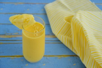 Pineapple smoothie on blue background