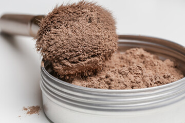 A jar of organic non-toxic chemicals free dry shampoo. DIY project for healthy low toxic living. Simple shampoo powder containing just natural ingredients, cocoa powder, cornstarch and essential oil.