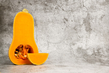 Wall Mural - Butternut squash with slices beside against concrete background. Healthy food.Print for stand for plates. Kitchen picture