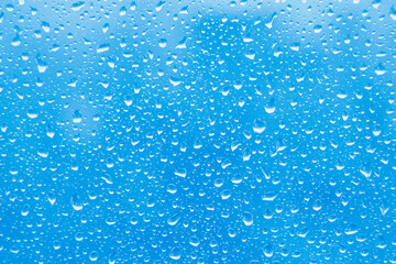  Water rain drops on blue glass surface as background. Abstract backdrop.