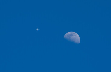 Wall Mural - Passenger plane and moon. During the day, with blue sky