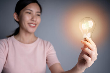 Poster - Business women hand holding light bulb, concept of new ideas with innovation and creativity