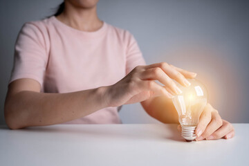 Poster - Business women hand holding light bulb, concept of new ideas with innovation and creativity