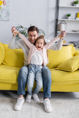 Wall Mural - Father and kid smiling at camera while holding hands.