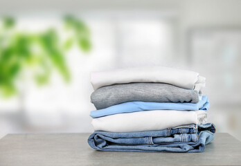 Wall Mural - Cotton folded clothes on table indoors. Clean apparel stacked. Stack of clothing.