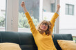 cheerful woman celebrating success on the sofa at home