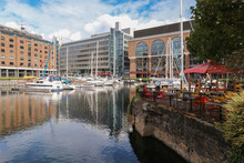 Cafe By The Water In St. Katharine Docks Marina, With View On Anchored Boats And Buildings In The Background