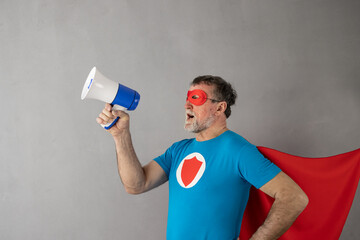 Sticker - Senior man wearing superhero costume shouting through loudspeaker