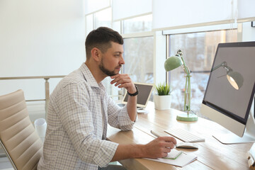 Wall Mural - Freelancer working with computer at table indoors