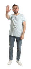 Wall Mural - Happy young man waving to say hello on white background