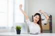 © Chanakon - Young beautiful asian business woman finish working and stretch oneself. Women finished work and rest She works at home in the living room.