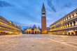 An empty St Marks square in Venice with the bell tower and the cathedral at dawn
