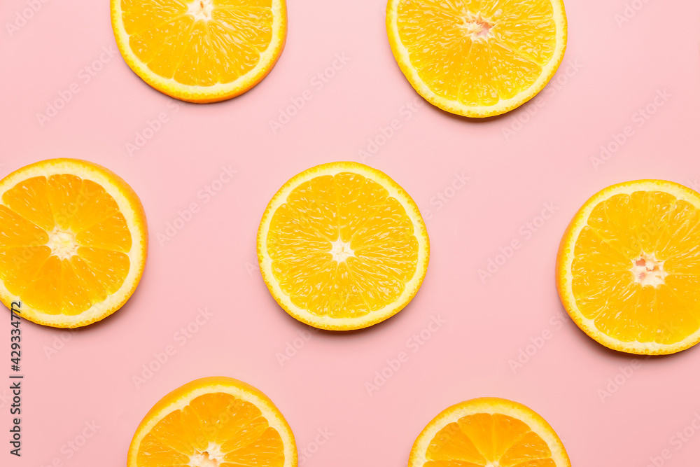 Slices of fresh oranges on color background