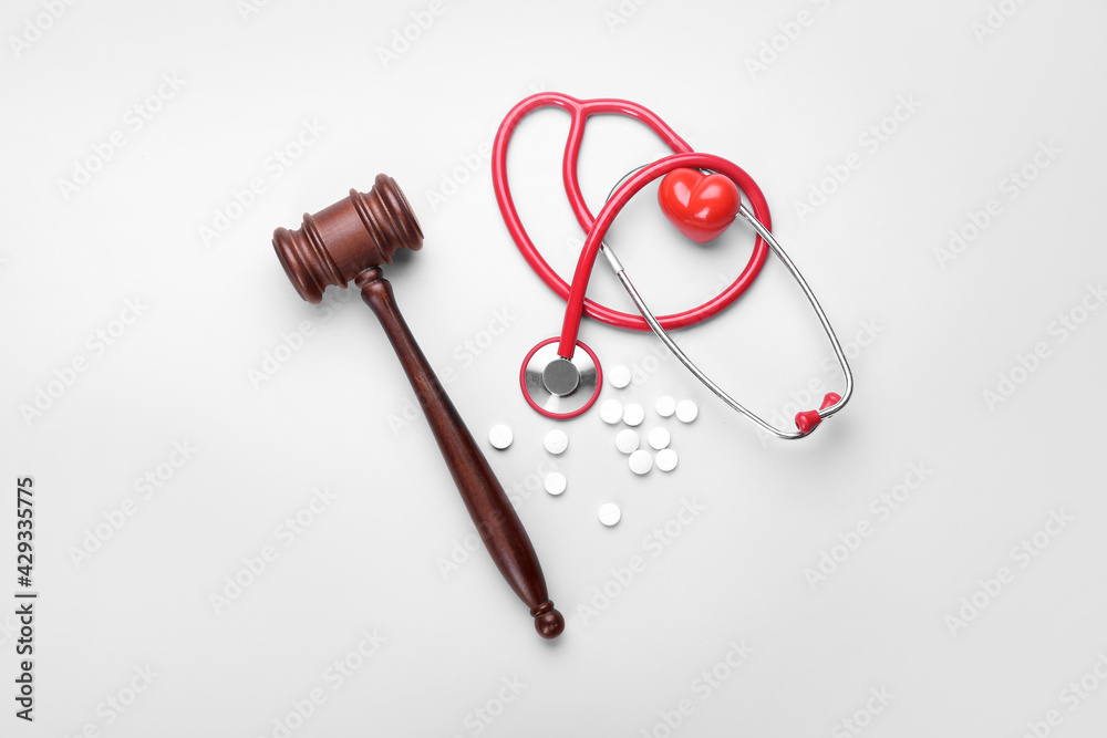 Judge gavel, heart, pills and stethoscope on white background. Concept of health care reform