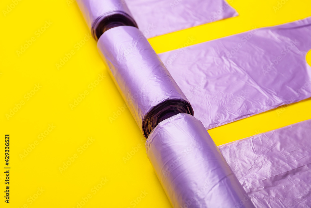 Rolls of garbage bags on color background