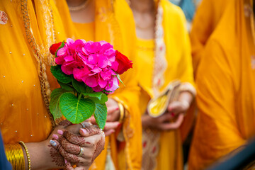 Indian bridesmaids' hands holding flowers close up