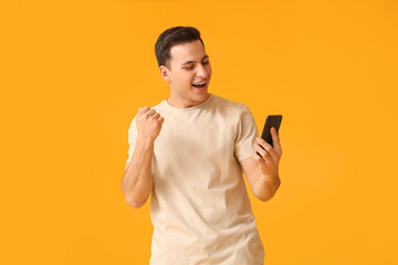 Wall Mural - happy young man with mobile phone on color background