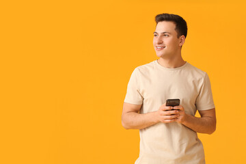 Wall Mural - handsome young man with mobile phone on color background